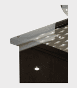 Tienda de muebles con escritorio moderno en madera oscura y superficie de cristal, decorativo y funcional. Ideal para oficina o estudio con iluminación que refleja la luz en el mobiliario.