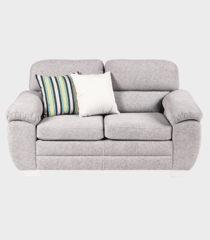 Sofá gris de mimbre con cojines decorativos en colores y texturas variadas, ideal para salones elegantes y confortables.
