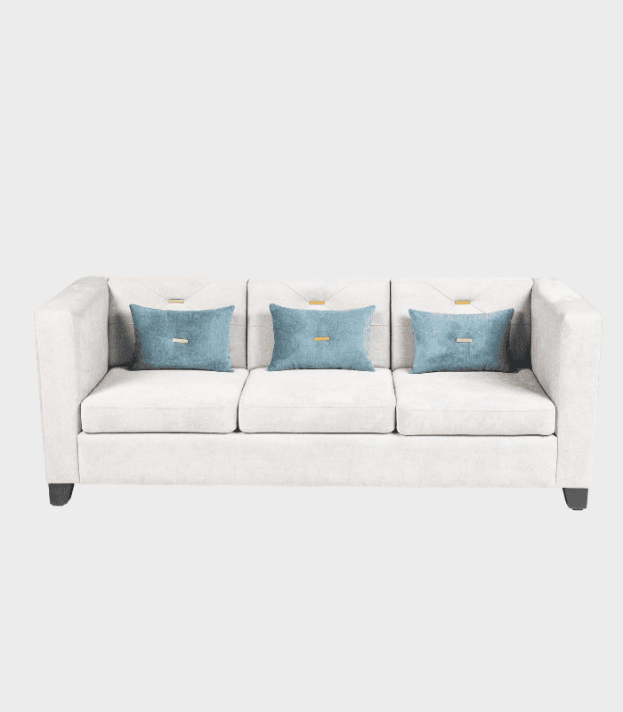 Sofá moderno en color gris claro con tres cojines azules, ideal para sala de estar, combina muebles y decoración contemporánea.