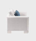 Sofá gris claro con cojines azules y blancos, en un estilo moderno y cómodo, perfecto para decoración interior en zonas de estar.