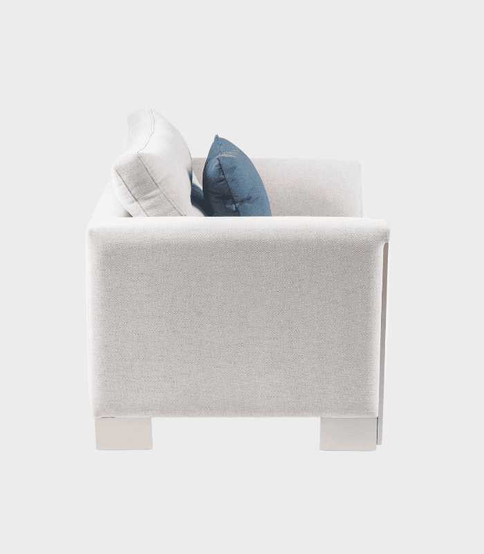 Almohada Calm Orange Blossom Infused - 2025-03-24T161939.776 Sofá gris claro con cojines azules y blancos, en un estilo moderno y cómodo, perfecto para decoración interior en zonas de estar.