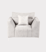 Elegante sillón de tono claro con cojín decorativo, ideal para sala de estar moderna y con estilo.