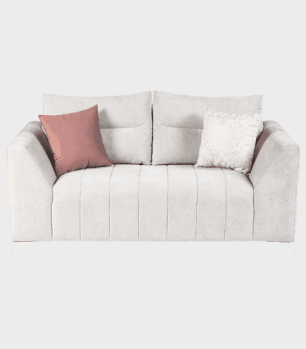 Butaca moderna en tonos neutros con cojines decorativos en rosa y beige.