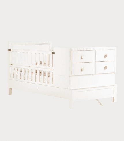 Babysitter cot with drawers in white, ideal for nursery decor and providing a safe sleep space for babies. Pero de guardería blanca, perfecta para decoración de habitación infantil y seguridad.