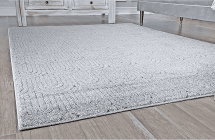 Suelo de alfombra gris en zona muebles con muebles de madera y sillones modernos.