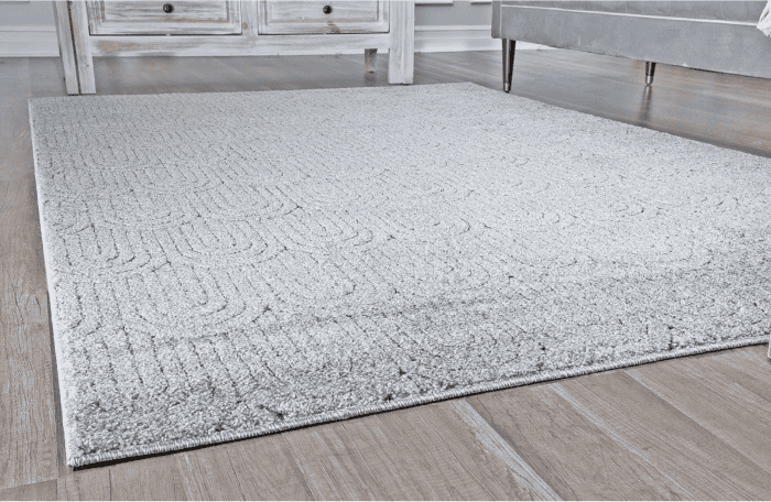 Suelo de alfombra gris en zona muebles con muebles de madera y sillones modernos.