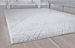 Suelo de alfombra en zona de salas con muebles de madera y sofá gris.