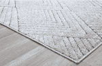Suelo con alfombra en tonos grises y muebles de madera clara, decorada con sillones y escritorios modernos para espacios de trabajo y descanso.