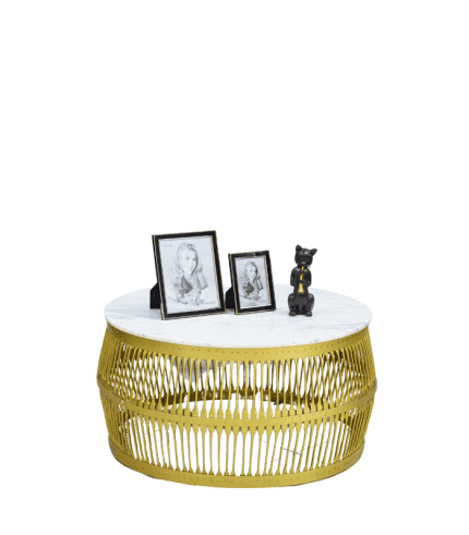 Bajo en imagen de una mesa de centro redonda con base de mimbre en color amarillo y superficie de mármol blanco, decorada con marcos de fotos y un pequeño oso de cerámica.