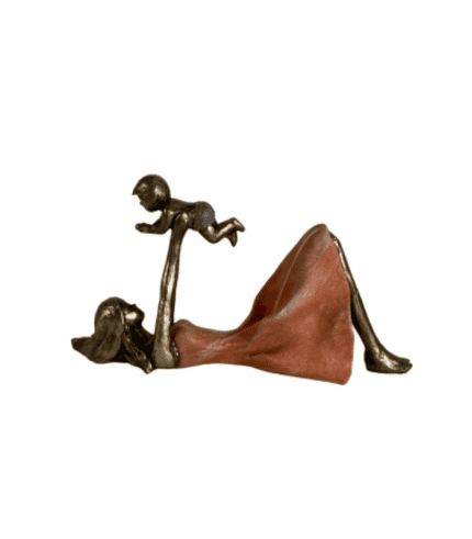 Juguete de escultura en forma de mujer acostada con un niño brincando en sus manos, hecha de metal y madera, decorativo, ideal para muebles y decoración de interiores.