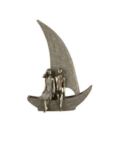 2. Figuras de pareja en una escultura de metal en forma de barco con luna, decorativa y artística.