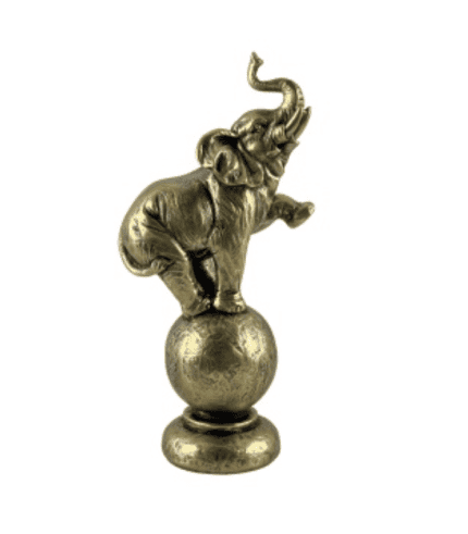Elefante de cerámica dorada equilibrado sobre una esfera, ideal para decorar espacios con estilo y originalidad. Perfecto para complementar muebles y la decoración de tu hogar u oficina.