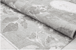 Alto text: Alfombra decorativa en tonos neutros con diseño floral y vintage para espacios elegantes y acogedores.