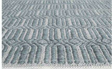 Suelo con tapete decorativo en tonos azules y blancos con patrón geométrico moderno.
