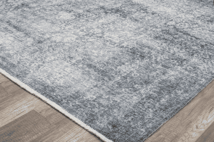 Alfombra gris sobre suelo de madera, ideal para decorar espacios modernos y elegantes en hogares y oficinas.