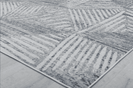 Suelo de alfombra gris con patrón geométrico, ideal para zonas de descanso y decoración moderna en espacios interiores.
