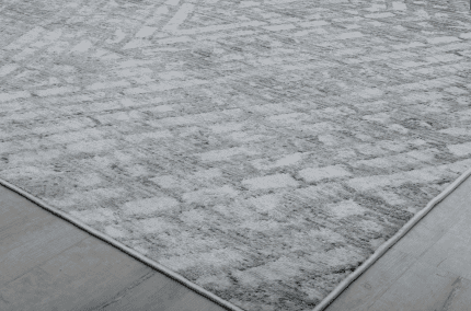Suelo de alfombra gris con textura suave y diseño moderno, ideal para decorar y complementar ambientes de sala o oficina. Perfecto para espacios que buscan confort y estilo.