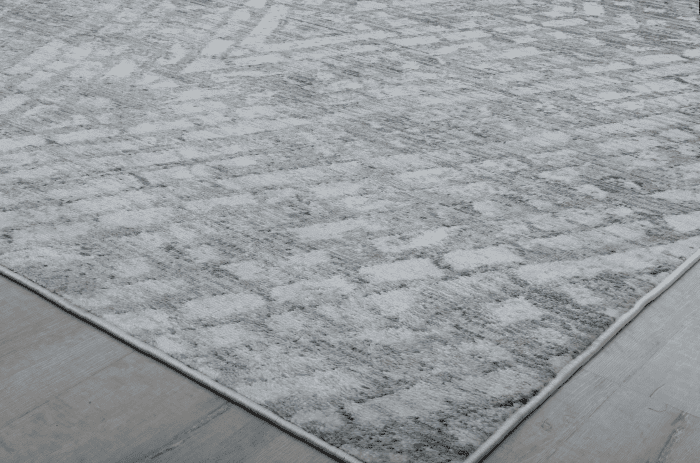 Suelo de alfombra gris con textura suave y diseño moderno, ideal para decorar y complementar ambientes de sala o oficina. Perfecto para espacios que buscan confort y estilo.