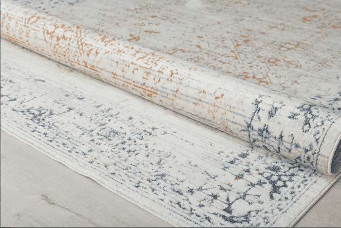 Bucle de alfombra con diseño clásico en tonos beige, gris y naranja, mostrando detalles y textura en un ambiente interior elegante y acogedor.