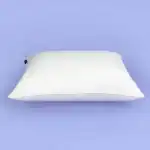 Suave almohada blanca sobre fondo azul claro, ideal para decorar y lograr un descanso cómodo con muebles y sillones en espacios acogedores y modernos.