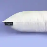 Suave almohada blanca con etiqueta "Beautyrest SOFT" sobre fondo lila.