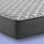 Colchón con tapizado gris y detalles en textura acolchada, diseñado para dormitorios y decoración moderna.