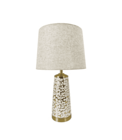 Lámpara de mesa con base decorativa en color blanco y detalles dorados, y pantalla en color beige para iluminar espacios de oficina o decoración en zonas de muebles y sillones.