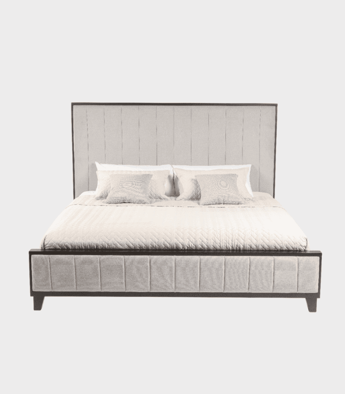 Sencilla cama con cabecera acolchada en tonos grisáceos, ideal para dormitorios modernos y elegantes, complementada con cojines en colores suaves para una decoración armoniosa.