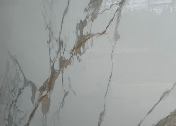 Blanco y gris mármol con vetas doradas, ideal para muebles y decoración interior moderna, creando un ambiente elegante y sofisticado en cualquier espacio.