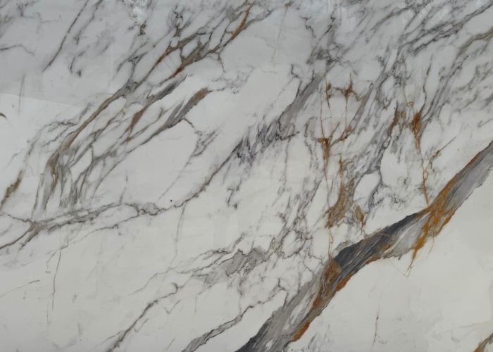 Mármol blanco con vetas grises y doradas, ideal para decoración y mobiliario elegante.