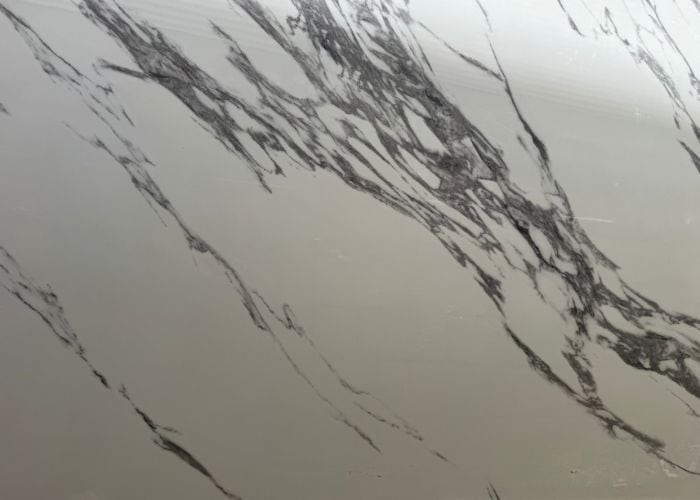 Blanco con vetas grises y negras que imitan el mármol, ideal para decorar espacios modernos y elegantes.