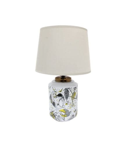 Lámpara de mesa con base decorativa de cerámica con estampado de aves y plantas, y pantalla de tela blanca. Ideal para decorar espacios y agregar iluminación cálida y original.